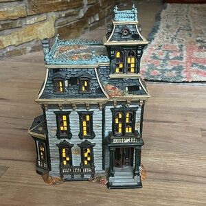 Snow village Halloween mordecai mansion. Windows glow with you use a candle.